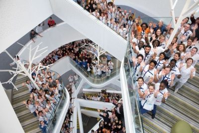 Group of healthcare professionals gathered on a hospital staircase, viewed from above.